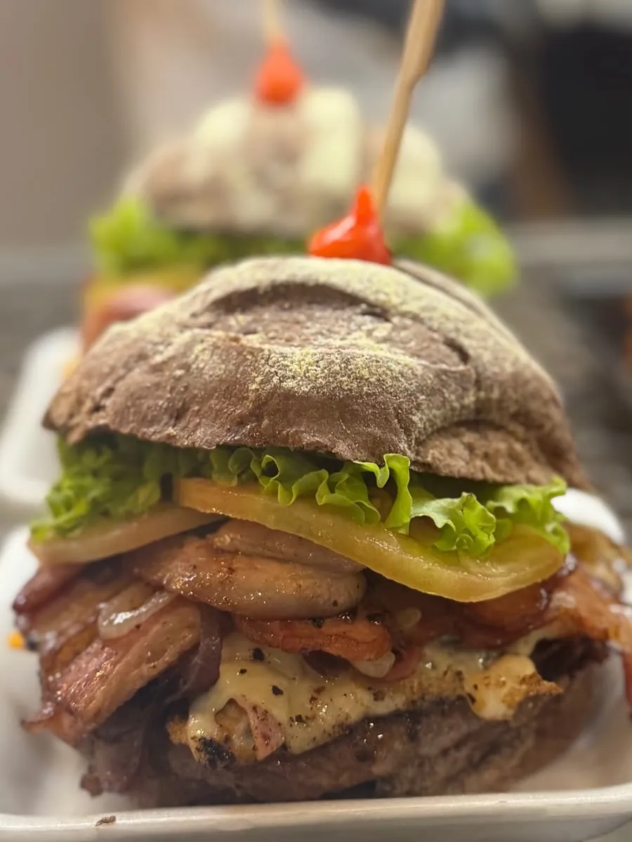 Hambúrguer no pão escuro com bacon, queijo e alface